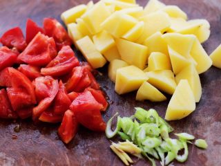 3、自制丸子一锅炖,土豆去皮洗净后，用刀切成滚刀块，番茄切块，葱姜切丝。