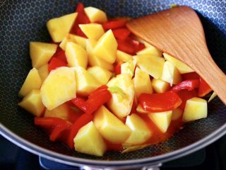 5、自制丸子一锅炖,加入土豆块继续翻炒片刻。