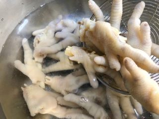 13、网红柠檬泡爪,鸡爪煮好用漏勺捞出来沥水,倒入其中一个纯净水的碗里