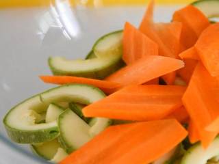 1、这道菜上桌朋友都爱吃，关键做法还简单易学,西葫芦去囊，切片，胡萝卜切菱形块放入碗中。