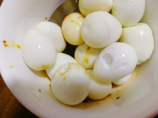 14、麻油滚蛋,今后将剥好皮的鹌鹑蛋，放入调好的料中。