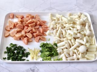 2、海鲜菇鸡蛋汤,洗净的海鲜菇洗净切小段,火腿从中间切开后再切片,葱姜香菜切碎。