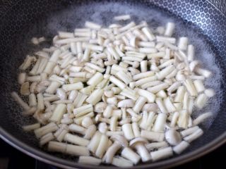 3、海鲜菇鸡蛋汤,锅中倒入适量的清水烧开,放入切段的海鲜菇,焯至变软捞出备用。