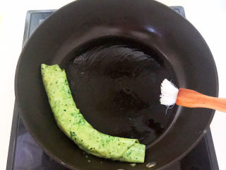 16、菠菜蛋卷,鸡蛋液定型后卷起来，尽量卷得紧实点，在锅的另一边再刷一层大豆色拉油