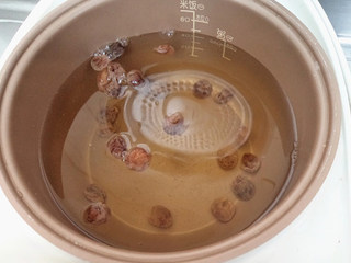 3、酸梨桂圆冰糖水,再加适量水后将内胆放入电饭煲，通电煲