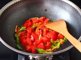 8、番茄啤酒炖鸭,倒入番茄大火继续翻炒至变软。