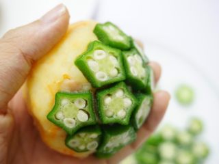 12、秋葵薯泥球,将秋葵一颗一颗贴在薯泥球的表面,尽量填满空隙,因为秋葵本来带有黏液,不会轻易掉下来,稍微用手轻轻按压一下即可。