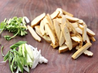 2、香干辣炒西葫芦,香干洗净用刀切成薄片，蒜苗和葱叶斜切成丝，香菜切段。