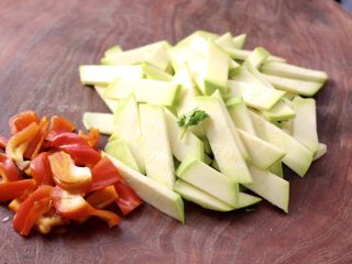 3、香干辣炒西葫芦,西葫芦也用刀切菱形薄片，红椒切块。