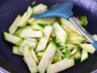 9、香干辣炒西葫芦,用锅里的底油，爆香剩下的葱丝，加入西葫芦薄片。