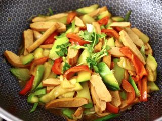 16、香干辣炒西葫芦,大火翻炒1分钟，撒上香菜段即可关火。