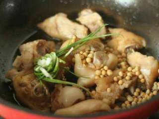 3、黄豆焖猪蹄,倒入适量生抽、料酒、冰糖，加入洗净的黄豆及葱结。