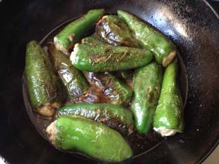 10、酿青椒,放入炸好的青椒盖上盖，中小火煮约8-10分钟，待汤汁收至较稠即可出锅