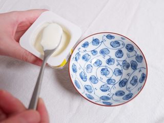 3、酸奶杯水果冻,用勺子舀出2~3勺酸奶，避免加入水果酸奶溢出来