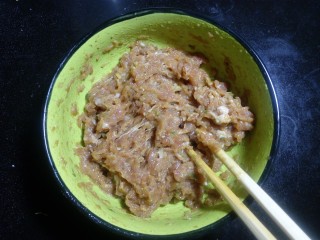 5、豆角焖肉饼,用筷子搅打均匀。