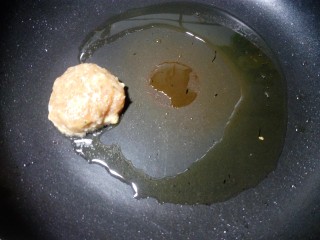 11、豆角焖肉饼,锅里放少许油,小火烧热后,用勺子取一勺肉馅,放在锅里煎。