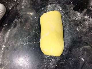 15、红萝卜白吐司,第二次擀卷，取一个面团，收口朝下，上下擀长