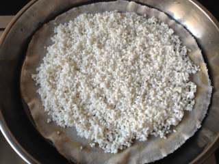 5、温州糯米饭,锅里倒入足够的冷水,放上蒸屉,再铺上一层湿润的纱布,把泡好的糯米沥干水分,平铺在纱布上