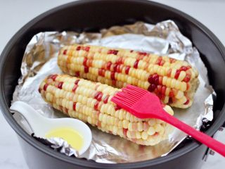 8、风味烤玉米,先用刷子蘸上橄榄油，把玉米均匀涂抹一遍。