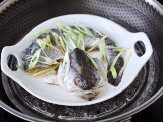 7、清蒸鲈鱼,锅中倒入适量的清水煮沸后，把腌制好的鲈鱼放入锅中。