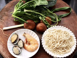 1、鲍鱼对虾香菇菠菜面,首先备好所有的食材。