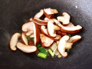 9、鲍鱼对虾香菇菠菜面,另起锅烧热后，倒入花生油烧热，先大火爆香蒜苗，再放入香菇片，大火快速进行翻炒片刻。