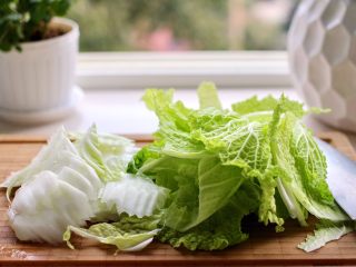 3、黑酱油+大白菜豆腐丸子炖海鲜,大白菜洗净后用刀把大白菜斜切成薄片、白菜帮和白菜叶区分开来