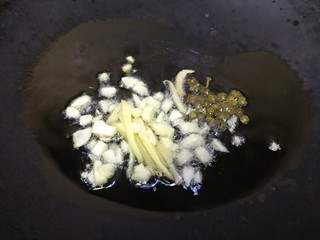 9、爆炒牛肚,热锅凉油,油微热放入姜丝、蒜末,麻椒粒,文火炒香。