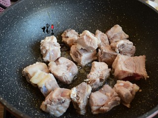 4、红烧芋头排骨,锅中加入油，再加，冰糖冰糖熬制深色加入排骨，翻炒均匀