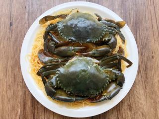 6、粉丝蒸青蟹,把粉丝码入盘底，再把青蟹一块一块拼起来放在粉丝上，恢复原状。