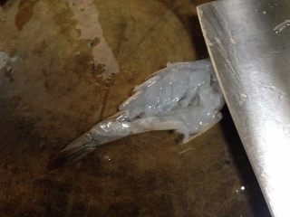 3、蒜蓉粉丝蒸大虾,用刀在虾身上平拍两下,再横向用刀在虾肉上剁几下