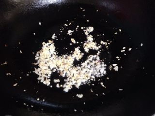 6、蒜蓉粉丝蒸大虾,锅内加油,小火把一半的蒜碎炒成浅金黄色