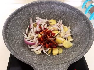 10、红烧鱼,加入圆葱，姜片和大蒜，加入干红辣椒，炒出香味