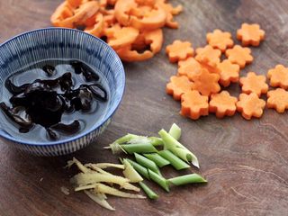 4、墨鱼丸子冬瓜木耳煲,胡萝卜刻成小花朵，葱姜切丝，木耳洗净泡发。