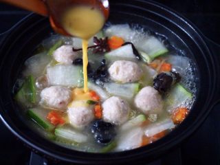 13、墨鱼丸子冬瓜木耳煲,倒入打散的鸡蛋液，继续大火烧开。