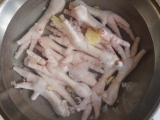 2、无骨蒜香鸡爪,冷水下锅，放入姜片，料酒，盐