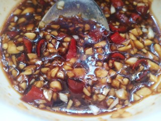 9、无骨蒜香鸡爪,取一个空碗，放入一头蒜砸成的末，小米辣，白糖，酱油，盐，醋，香油，用勺子搅拌均匀