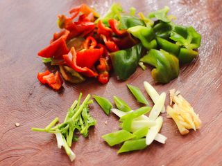 5、土鸡土豆粉条一锅炖,把青红辣椒洗净后，用刀切成片，葱姜切丝，香菜切段。