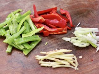 2、鱼锅片片,把青红辣椒洗净切成条，葱姜切丝。