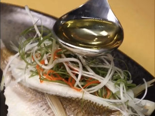 12、葱油鲈鱼,出锅,摆上切好的葱丝,起锅烧热油,用热油浇葱丝爆出香味