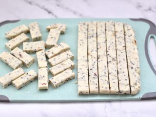 13、芝麻核桃糖,待芝麻花生糖放至微微变得有点余温时，用刀先切成1厘米左右的长条，再切成4厘米左右的大小块。