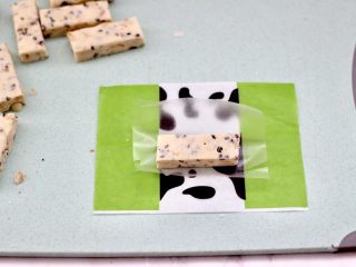 14、芝麻核桃糖,把切好的芝麻花生糖，先裹上一层糯米纸。