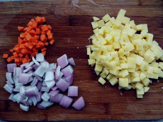 2、西红柿土豆炖牛肉,将土豆、胡萝卜、洋葱和苹果都切成丁备用