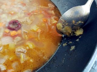 12、西红柿土豆炖牛肉,用勺底将部分土豆丁碾成泥,混在汤中