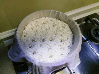5、自酿米酒,放入干净的笼布中，隔水蒸。(一定要插汽孔如图)