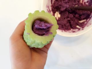 6、紫薯南瓜苦瓜圈,往苦瓜里塞入紫薯泥，可根据苦瓜内圈大小，将紫薯泥捏成一长条再塞入压实（不压实切片的时候苦瓜圈和内陷易分离）。