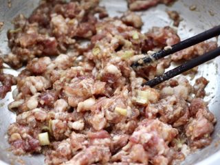 6、胡萝卜青椒海米饺子,把五花肉馅和所有的调料混合后，顺时针方向搅拌上劲。
