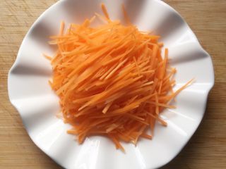 2、香煎土豆丝饼,将红萝卜去皮洗净，切成细丝，越细越好。