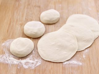 14、杏鲍菇酱肉发面包,排气揉匀后，切成大小一致的剂子，擀成圆形面皮。