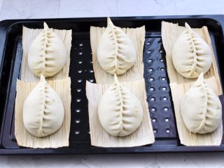 16、杏鲍菇酱肉发面包,把包好的包子放入蒸屉上。